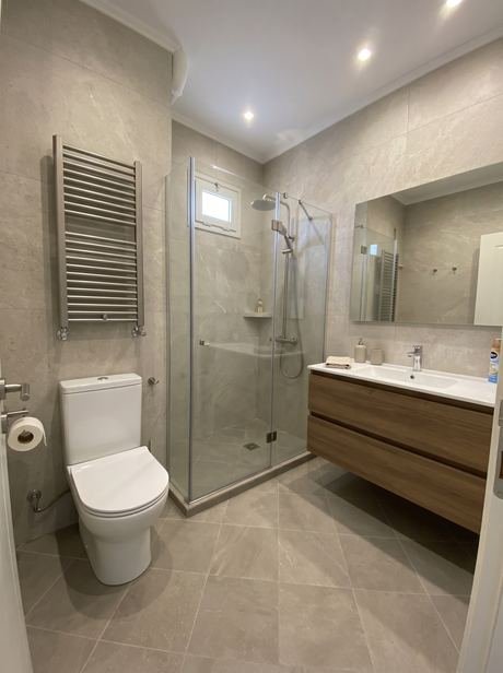 Yenilenen banyoda duş bölümü ve lavabo dolabı görünümü
